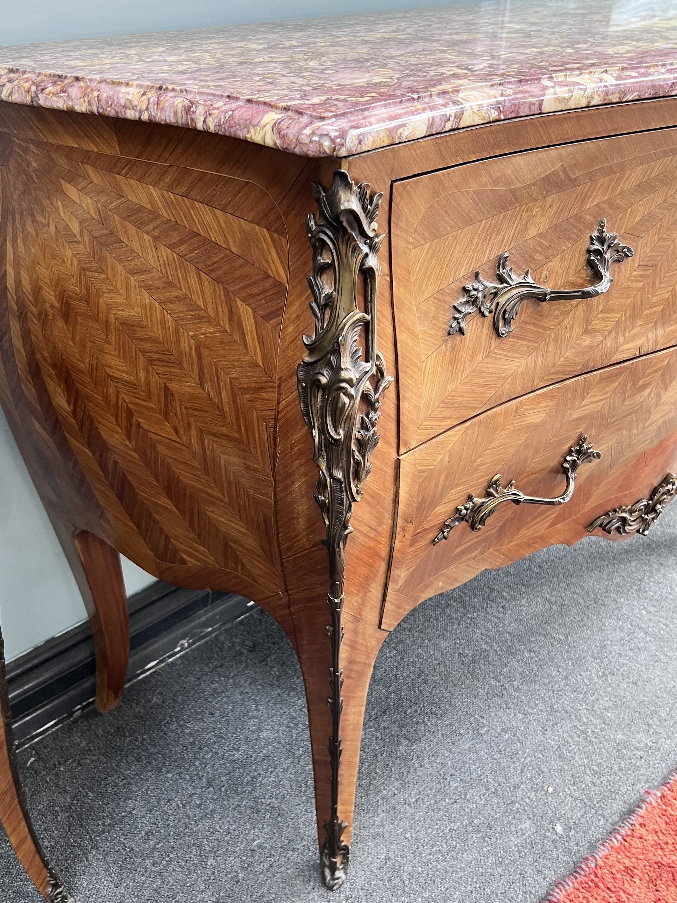 A French Louis XVI style parquetry bombe fronted rouge marble topped commode, width 120cm, height 85cm